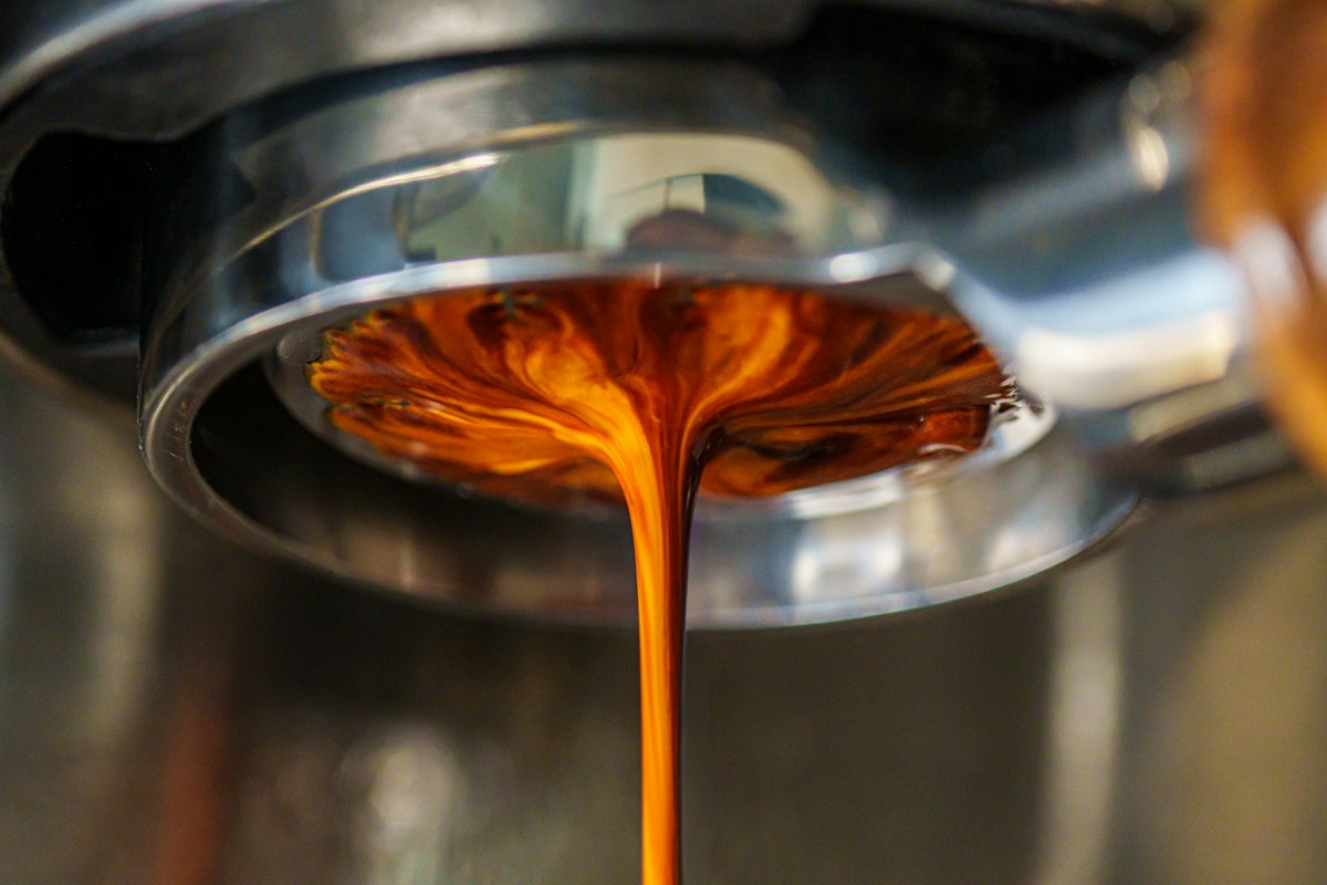 Espresso extracting through a portafilter, illustrating sour espresso troubleshooting